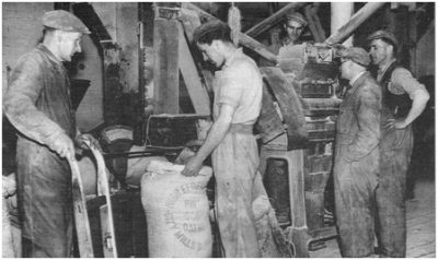 Photo of a sack of oatmeal being weighed at the mill by Alec Ogilvie. Others (left to right) are James Pringle, Sam Somerville, Jack Scott and Neil Williamson